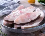 Świeże kawałki halibuta w szklanej misce, gotowe do przyrządzenia. Zapach halibuta na jakie ryby?
