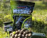 Profesjonalne kulki na karpia Instinct Umami w słoiczku i opakowaniu. Na łopatce widoczne są gotowe do użycia kulki proteinowe.