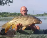 Złowiłem pięknego karpia na łowisku Extra Carp Niwka. Ryba jest duża, złocista i ma charakterystyczne wąsy.