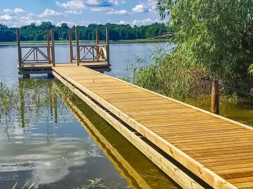 Drewniane pomosty nad jeziorem, idealne na letnie wypady nad wodę. Stawy komercyjne zapraszają do relaksu.