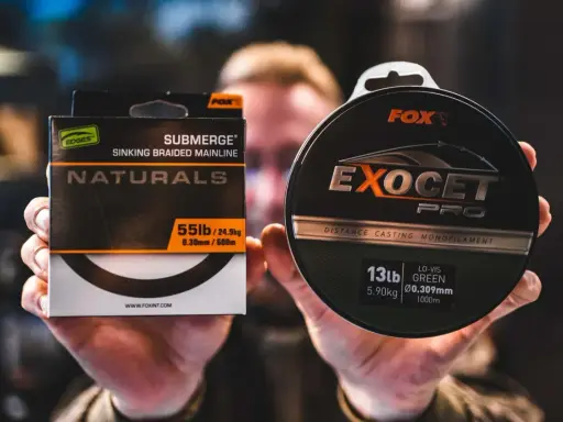 Dłonie trzymają pudełko z plecionką Fox Submerge Naturals i szpulę żyłki Fox Exocet Pro.