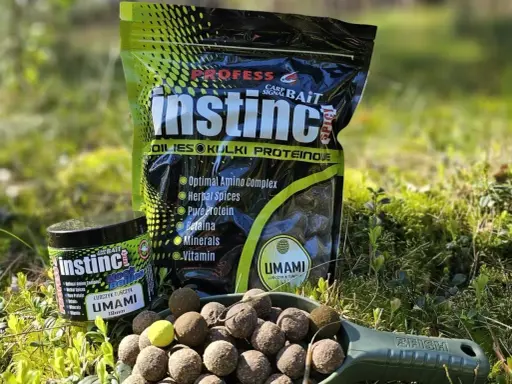 Profesjonalne kulki na karpia Instinct Umami w słoiczku i opakowaniu. Na łopatce widoczne są gotowe do użycia kulki proteinowe.