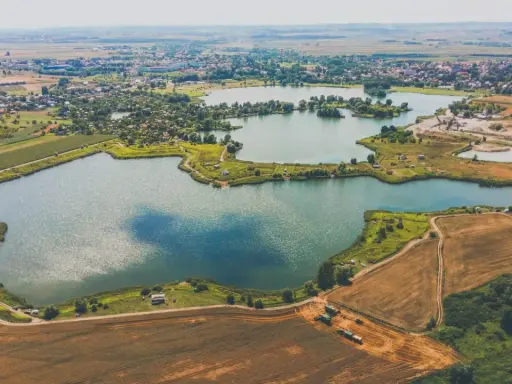 Malownicze łowisko Radymno z lotu ptaka. Jeziora, pola uprawne i zabudowania tworzą piękny krajobraz.