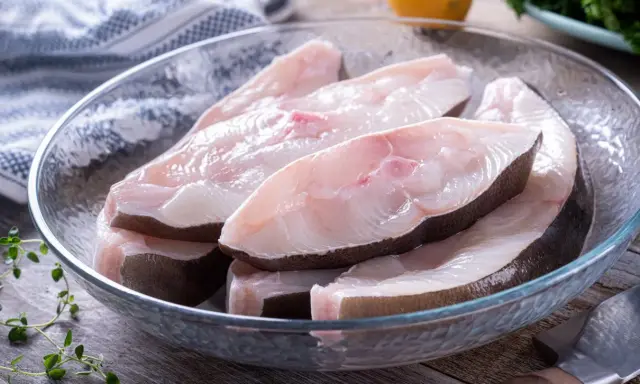 Świeże kawałki halibuta w szklanej misce, gotowe do przyrządzenia. Zapach halibuta na jakie ryby?