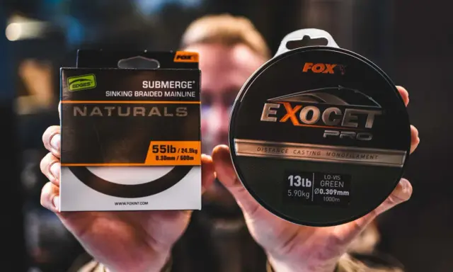 Dłonie trzymają pudełko z plecionką Fox Submerge Naturals i szpulę żyłki Fox Exocet Pro.
